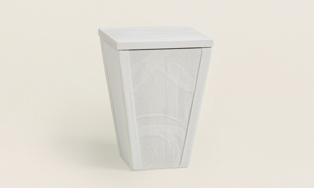 Valkealla kankaalla päällystetty kapeneva uurna.