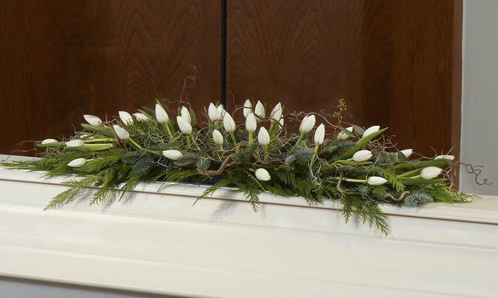 Valkoista tulppaania ja peikonpähkinän oksaa.